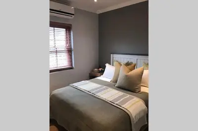 a bedroom with a bed with pillows and a window at Winner in the Winelands in Franschhoek