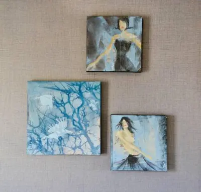 three paintings of a woman on a wall at Church Street Luxury Apartments in Stellenbosch