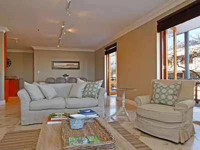a living room with a couch and two chairs and a table at Church Street Luxury Apartments in Stellenbosch