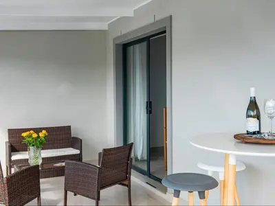 a living room with a table and chairs and a table and a tablektop at Elizabeth House in Hermanus