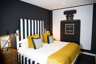 a bedroom with a bed with yellow and black stripes at Franschhoek Maison du Cap in Franschhoek