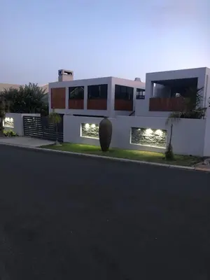 a large white house with lights in front of it at Spoelklippies in Hermanus