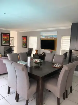 a dining room with a table and chairs at Spoelklippies in Hermanus
