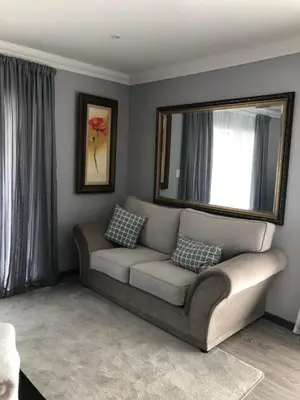 a living room with a couch and a mirror at Spoelklippies in Hermanus