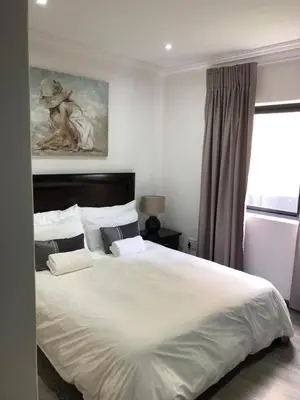 a bedroom with a large white bed and a window at Spoelklippies in Hermanus