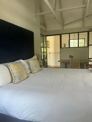 a large white bed with two pillows on it at Comfortable Room with Large en suite Bathroom in Franschhoek