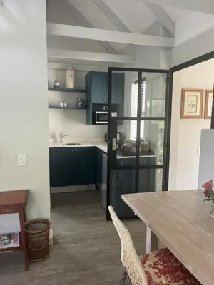 a kitchen with blue cabinets and a wooden table at Comfortable Room with Large en suite Bathroom in Franschhoek