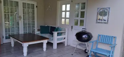 a room with a table and a desk and chairs at Summer House in Hermanus