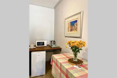a room with a table with a vase of flowers at Le Grec Wine Tram Apartment #1 in Franschhoek