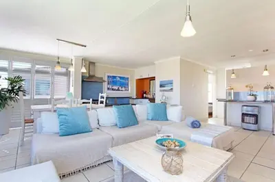 a living room with a couch and a table at Hermanus Beach Club - 106 - Apartment with a view in Hermanus