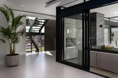a living room with glass doors and a potted plant at Villa de luxe in Franschhoek