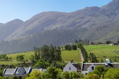 a village in a valley with mountains in the background at Villa de luxe in Franschhoek