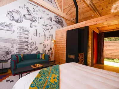 a bedroom with a bed and a wall with drawings on it at PitStop Lodge in Gordonʼs Bay
