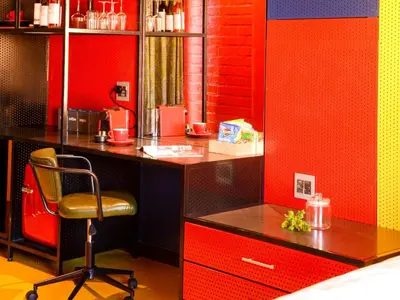 a desk with a chair in a room with red walls at PitStop Lodge in Gordonʼs Bay