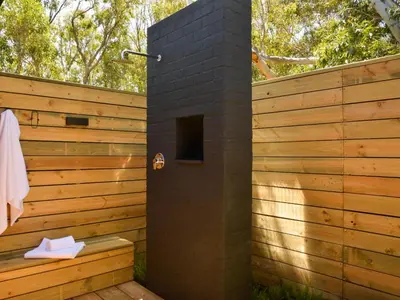 a brick outdoor shower with a wooden fence at PitStop Lodge in Gordonʼs Bay