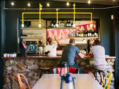 a group of people sitting at a bar at PitStop Lodge in Gordonʼs Bay