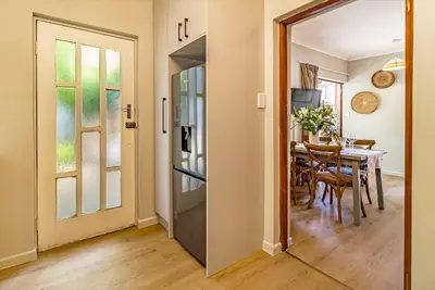 a dining room with a table and a mirror at Villa Helderberg in Somerset West