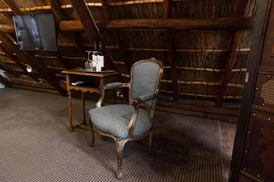 a chair in a room with a table and a television at Weltevreden Estate in Stellenbosch
