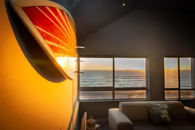 a lamp in a living room with a view of the ocean at Spacious Luxury 3 Bedroom Apartment B401 Sea Spray in Bloubergstrand