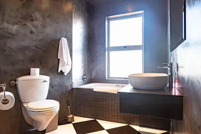 a bathroom with a toilet and a sink and a window at Spacious Luxury 3 Bedroom Apartment B401 Sea Spray in Bloubergstrand