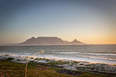a view of the ocean with a mountain in the background at Spacious Luxury 3 Bedroom Apartment B401 Sea Spray in Bloubergstrand