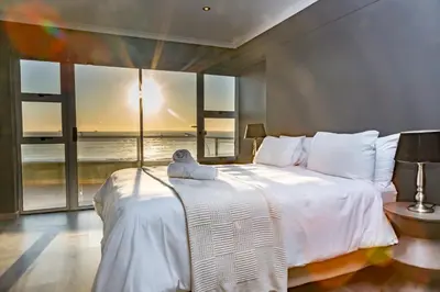 a bedroom with a bed with a stuffed animal on it at Spacious Luxury 3 Bedroom Apartment B401 Sea Spray in Bloubergstrand
