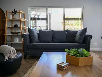 a living room with a black couch and a table at Portico 501 / 904 in Cape Town