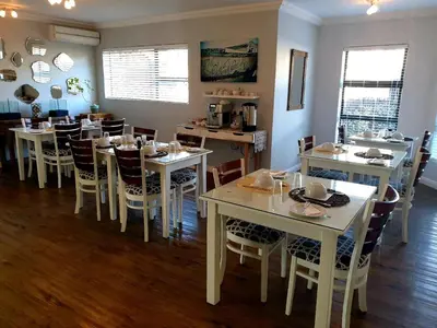 a dining room with white tables and chairs at Portico 501 / 904 in Cape Town
