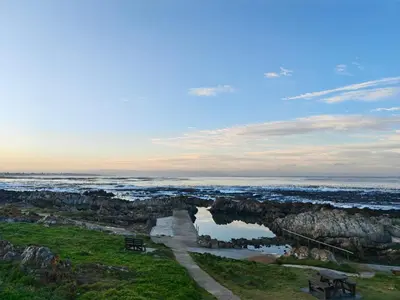 a view of the ocean from a bluff with benches at Karibu Self-catering Accommodation in Hermanus