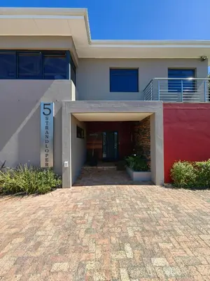 a house with a brick driveway in front of it at Karibu Self-catering Accommodation in Hermanus