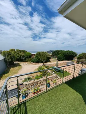 a balcony with potted plants on it at Karibu Self-catering Accommodation in Hermanus