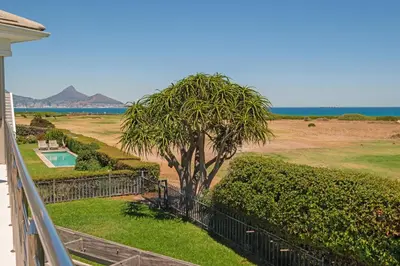 a balcony with a tree and a view of the ocean at Kite View Villa @2 in Cape Town