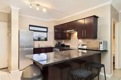 a kitchen with a counter top and a refrigerator at Waterstone East F201 in Cape Town