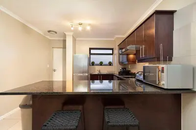 a kitchen with a counter top with a refrigerator at Waterstone East F201 in Cape Town