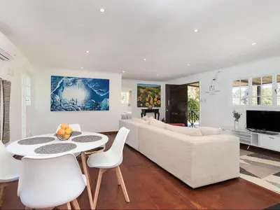 a living room with a white couch and a table and chairs at La Ferme Guest Farm - Hot Tubs in Franschhoek
