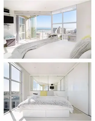 a bedroom with a large bed and a large window at Designer Flat with scenic views in Cape Town