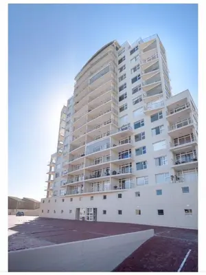 a large white apartment building with a parking lot at Designer Flat with scenic views in Cape Town