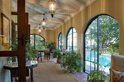 an open hallway with windows and a dining room with plants at Deux Frères Wine Estate & Luxury Villas in Stellenbosch