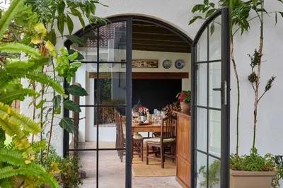 an arthouse conservatory door leading into a dining room at Deux Frères Wine Estate & Luxury Villas in Stellenbosch