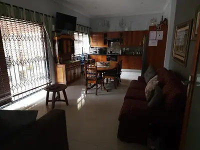a living room with a couch and a table and a kitchen at Perhethian in Cape Town