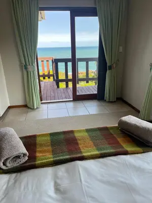 a bedroom with a bed with a view of the ocean at Jocks Place (on the sea) in Bettyʼs Bay