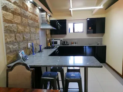 a kitchen with a large counter with stools in it at 20 On Percy in Cape Town