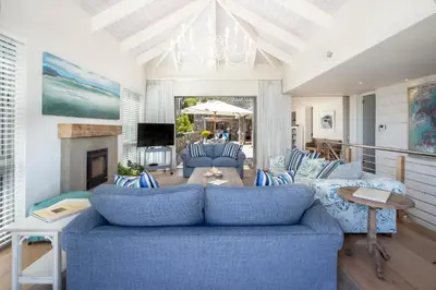 a living room with a blue couch and a fireplace at Splendour Hermanus in Hermanus