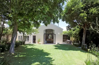 a white house with a yard with trees at Tugela in Franschhoek