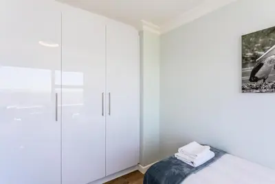a bedroom with white cabinets and a bed at Ocean View A1101 by CTHA in Bloubergstrand