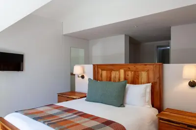 a bedroom with a bed with a wooden headboard at Minserie Collection in Stellenbosch