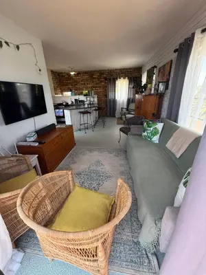 a living room with a couch and wicker chairs at Hemel in Hermanus Three bedroom Home in Hermanus