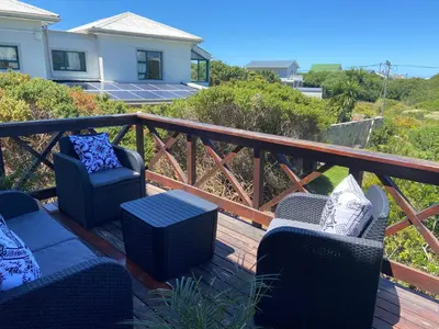 two chairs and a table on a deck at Hemel in Hermanus Three bedroom Home in Hermanus