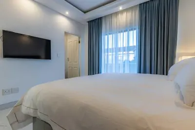 a bedroom with a large bed and a large window at Oceanway Boutique Hotel/Conference in Cape Town