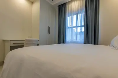 a bedroom with a large white bed and a window at Oceanway Boutique Hotel/Conference in Cape Town